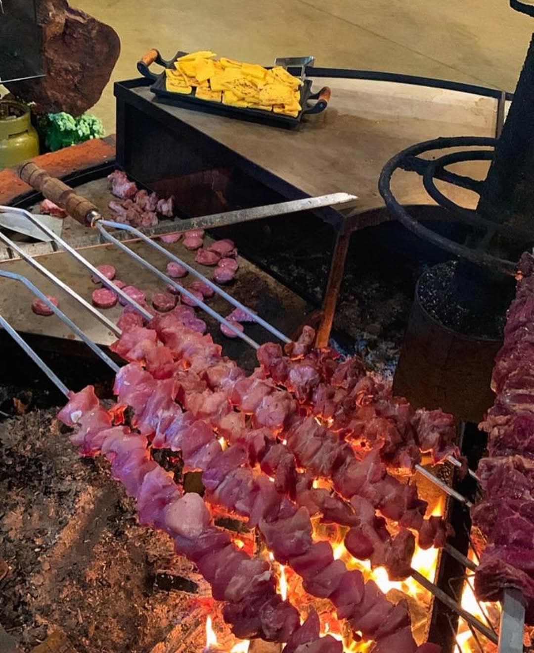 Carnes na lenha sendo preparadas na Invernada do Sol